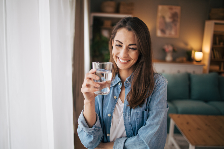 Happy woman with a glass full of crystal clear water